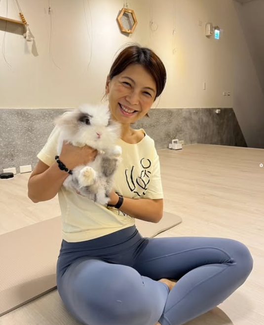 Michelle 老師在教室裡，懷中抱著一隻兔子